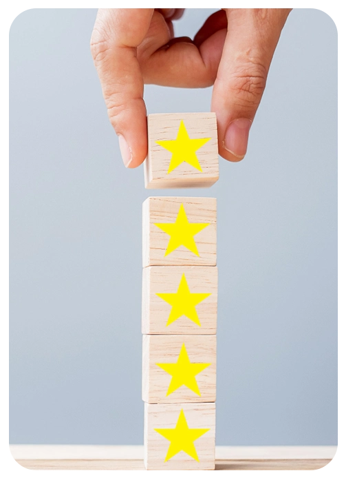 Mano colocando un bloque con estrellas amarillas, simbolizando la valoración y opiniones reales sobre cursos online